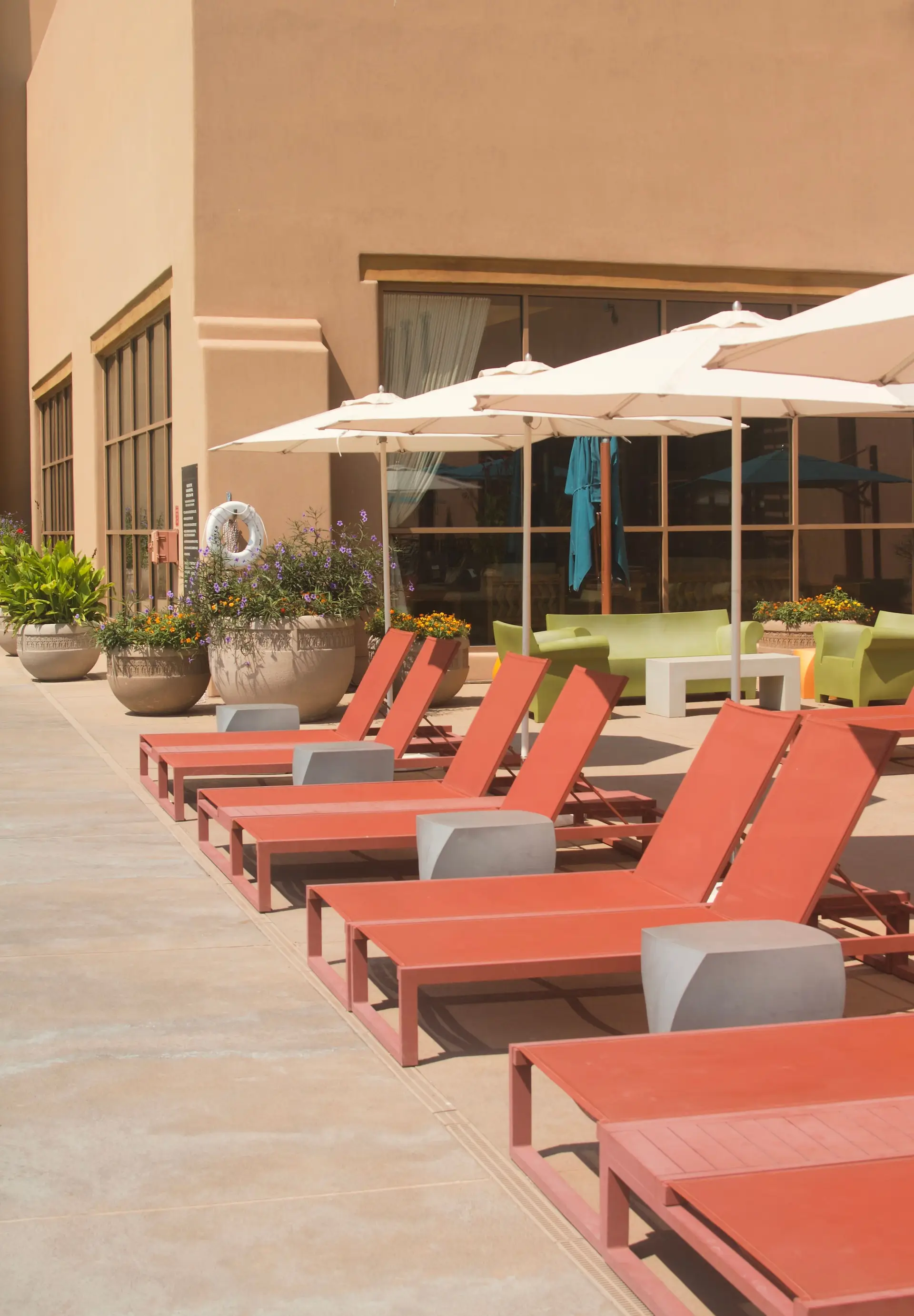 Rooftop pool deck with red lounge chairs